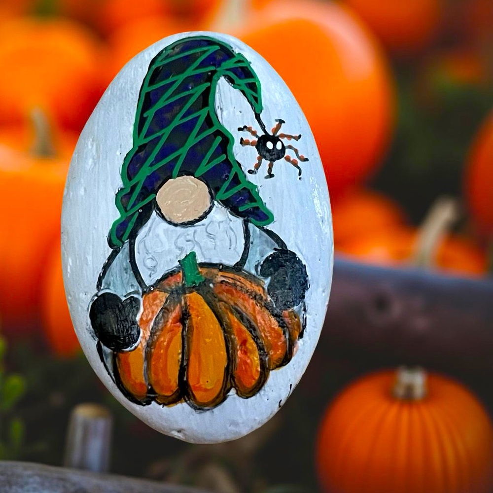 Hand crafted painted Halloween gnome rock white background orange pumpkin spider